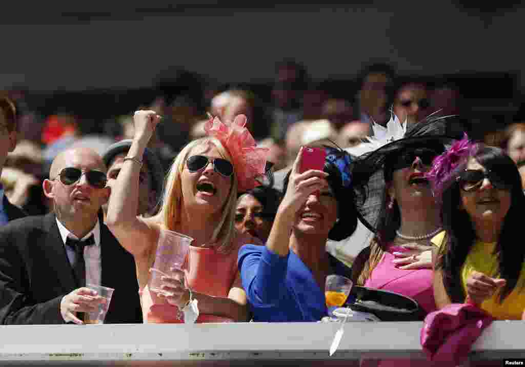 Racegoers react during the third race of Ladies Day in the Royal Enclosure at the Epsom Derby Festival in Epsom, southern England.