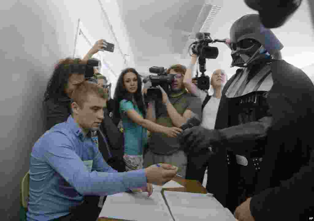 Darth Vader, the Ukrainian Internet Party candidate for Kyiv&#39;s mayor, waits to receive his ballot at a polling station in Kiev.