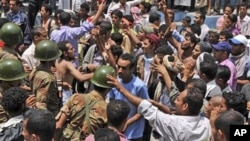 Yemeni army soldiers block the way as anti-government protestors attend a demonstration demanding the resignation of Yemeni President Ali Abdullah Saleh, in Taiz, Yemen, April 10, 2011