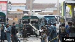 Afghan security forces inspect the damage caused by a suicide bombers at the site of the attackon the western outskirts of Kabul, Afghanistan, June 30, 2016. 