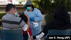 Medical official Rita Ray collects tissue from Sebastian Henandez, 5, for a COVID-19 test at Families Together of Orange County community health center in Tustin California on January 6, 2022. (AP Photo/Jae C. Hong, File)