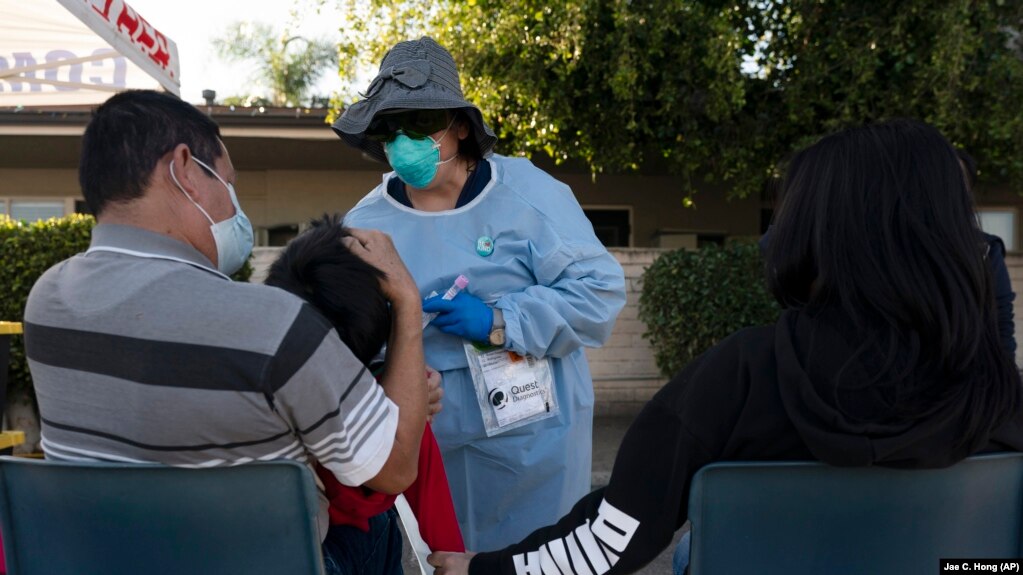 Medical official tests child, 5, for COVID in California on Jan 6, 2022 (AP Photo/Jae C. Hong, File)