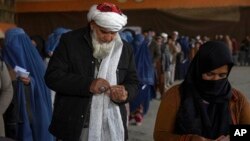 Afganos reciben dinero del Programa Mundial de Alimentos en Kabul, Afganistán, el 20 de noviembre de 2021.