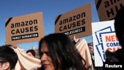 Demonstrators hold signs during a protest against Amazon in the Long Island City section of the Queens borough of New York, Feb. 14, 2019.