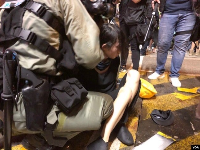 香港防暴警察在上环清场中拘捕一位女孩 （美国之音海彦拍摄 ）