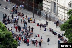 People are seen in the area known as the "flow" where people buy and use drugs in an area known as "cracolandia," or crackland, a dangerous wasteland of about eight blocks in the historic center of Sao Paulo, Brazil, March 9, 2021. REUTERS/Amanda Perobell