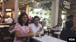 Sonal Jain (right in white shirt) takes a break from office to relax over a cup of tea with a friend. (A. Pasricha/VOA)
