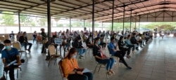 Garment workers returning to Phnom Penh after the Khmer New Year celebration are waiting for a health checkup at the Special Economic Zone in Phnom Penh, Cambodia, April 20, 2020. (Nem Sopheakpanha/VOA Khmer)