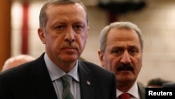 محمد ظفر چالایان (راست)، وزیر پیشین اقتصاد ترکیه است. 