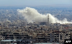 A general view taken from a government-held area in Damascus shows smoke rising from the rebel-held enclave of eastern Ghouta on the outskirts of the Syrian capital following fresh airstrikes and rocket fire, Feb. 27, 2018.
