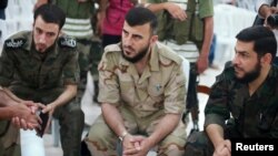 Zahran Alloush, komandan pasukan Jaish al-Islam (tengah). Kelompok terakhir pemberontak ini mengakui kekuasaan Suriah atas Ghouta dan akan menyerahkan senjata berat mereka.