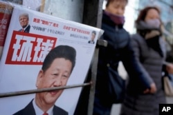 FILE - Women walk past a news stand displaying a Chinese news magazine fronting a photo of Chinese President Xi Jinping and U.S. President Donald Trump in Beijing, Feb. 9, 2017.