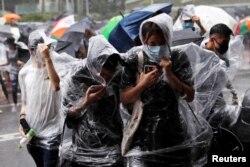 En Hong Kong, partidarios de los acusados se congregaron cubriéndose con paraguas de la lluvia en el exterior del tribunal.