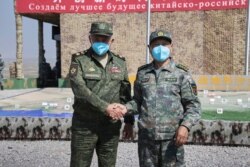 在中俄军队举行2021年联合军演期间，俄罗斯国防部长绍伊古抵达中国宁夏青铜峡与中国国防部长魏凤和（右）见面。（2021年8月13日）