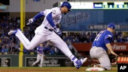 Kansas City Royals' Paulo Orlando beats the throw to first taken by New York Mets' Lucas Duda (21) during the 12th inning of Game 1 of the Major League Baseball World Series, Oct. 27, 2015, in Kansas City, Mo. 