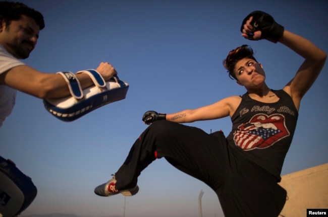 FILE - Zahra Afridi (R) kicks a punching bag during a kickboxing training session at her home in Islamabad on February 10, 2014. (Reuters)