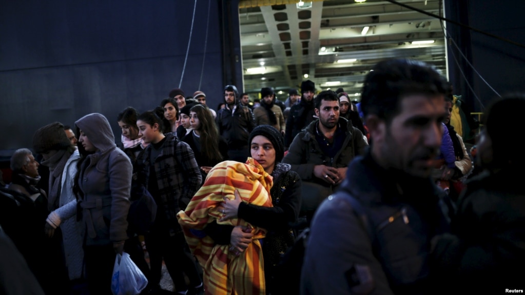 Refugees and migrants arrive aboard the passenger ferry Nissos Rodos at the port of Piraeus, near Athens, Greece, Jan. 13, 2016.