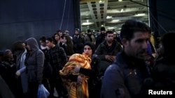 Para pengungsi dan migran menaiki kapal ferry Nissos Rodos di pelabuhan Piraeus, dekat Athena, Yunani, 13 Januari 2016.