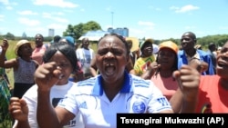 Zimbabwean war veterans who had gathered to demonstrate against a faction within the ruling Zanu PF party, reportedly led by the First Lady Grace Mugabe, vent their anger after they were dispersed by police using tear gas and water cannons in Harare, Thursday, Feb. 18, 2016. Mugabe was instrumental in the ouster of Zimbabwes first deputy President Joice Mujuru in 2014. (AP Photo/Tsvangirayi Mukwazhi)