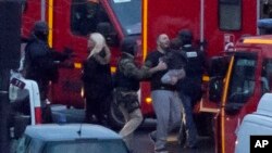 프랑스 경찰이 9일 파리 시내에서 벌어진 인질극을 진압한 가운데, 인질로 붙잡혔던 남성과 아이가 경관들의 도움을 받아 구급차에 오르고 있다.