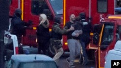 A security officer directs freed hostages to safety after police stormed a kosher market to end the situation in Paris, Jan. 9, 2015.