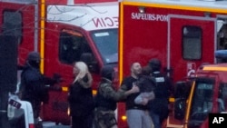 Працівник безпеки скеровує звільнених заручників після штурму крамниці, захопленої озброєним чоловіком, Париж, 9 січня 2015 р.