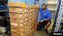 FILE - Parts department worker Frank Jorge stands next to boxes containing recalled Takata air bag inflators that were removed at the AutoNation Honda dealership in Miami, Florida, June 25, 2015. A teenager in the United States has become the 11th person worldwide to die because of a defective automobile airbag.