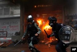 La policía antidisturbios llega al distrito comercial de Hong Kong, después que manifestantes vandalizaron el área, el domingo 29 de septiembre de 2019.