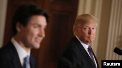 Presiden AS Donald Trump (kanan) mendengarkan Perdana Menteri Kanada Justin Trudeau berbicara dalam komferensi pers gabungan di Washington (13/2). (Reuters/Carlos Barria)