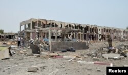 FILE - Damaged houses are seen one day after a Saudi-led air strike hit them in Yemen's western city of Mokha, July 26, 2015.