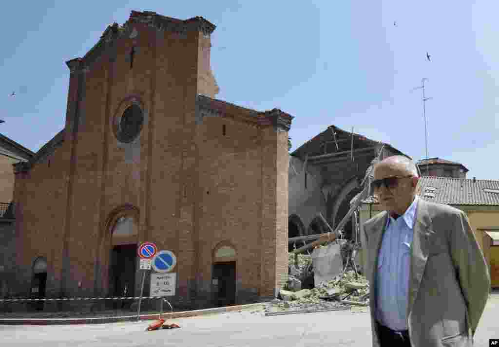 A man walks in front of a collapsed church in Mirandola, northern Italy, May 29, 2012.