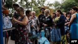 Люди стоять у черзі, щоб купити питної води, Донецьк, 18 серпня 2014 року