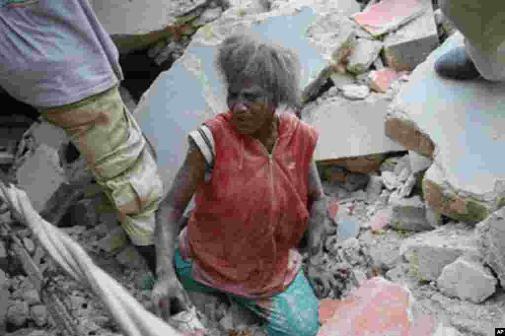 A Haitian woman is helped from the rubble of a damaged building in Port-au-Prince after a huge earthquake measuring 7.0 rocked the impoverished Caribbean nation of Haiti, 12 Jan 2010 – AFP