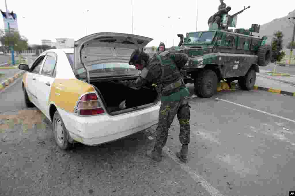 A policeman checks a car at a checkpoint near the U.S. embassy in Sanaa, Yemen, August 6, 2013. 
