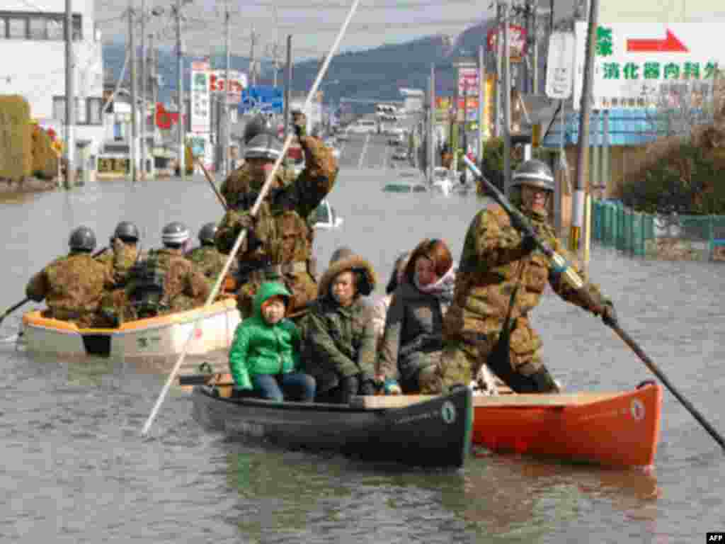 Self-Defense Force officers rescue people by a boat after a tsunami and earthquake in Ishinomaki City in Miyagi Prefecture March 12, 2011.