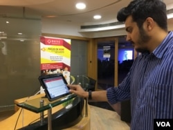 Akshay Chaturvedi, who recently began his own startup, checks in to a communal office space on an iPad. (E. Sarai/VOA)