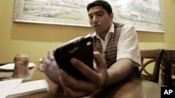 Bigyan Bhandari, a 28-year-old Nepali who works at a Nepalese restaurant run by K.P. Sitoula, uses his smartphone to call his family members in Kathmandu during an interview in Seoul, South Korea, April 27, 2015.