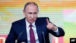 Presiden Rusia Vladimir Putin memberi isyarat saat konferensi pers tahunannya di Moskow, Rusia, Kamis, 14 Desember 2017.