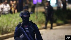 FILE - Officers stand guard at the site where an explosion that police said came from a firecracker, near the venue of the presidential candidates debate in Jakarta, Indonesia, Feb. 17, 2019. 