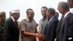 Somali President Mohamed Abdullahi "Farmajo" Mohamed, left, introduces new Prime Minister of Ethiopia Abiy Ahmed, center, to his ministers in Mogadishu, Somalia, June 16, 2018.