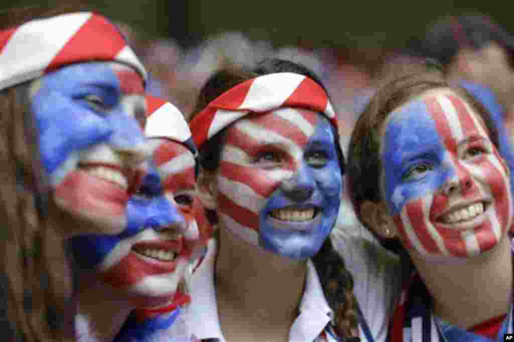 Para pendukung tim AS dengan wajah dicat bendera Amerika di stadion di Vancouver, British Columbia di Kanada (5/7). (AP/Elaine Thompson)