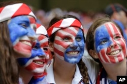 Fans of the United States with painted faces smile in the stands before the FIFA Women's World Cup soccer championship between the U.S. and Japan in Vancouver, British Columbia, Canada, Sunday, July 5, 2015. (AP Photo/Elaine Thompson)