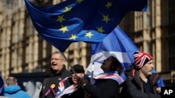 Anti-Brexit remain in the European Union supporters shout slogans during a protest outside the Houses of Parliament in London, March 14, 2019. 