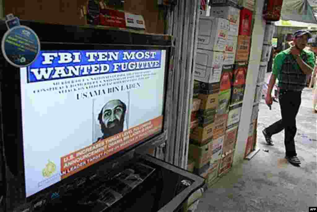 An Afghan youth walks past by a television announcing the death of Al-Qaida leader Osama bin Laden at a market in Kabul, Afghanistan, May 2, 2011 (AP)