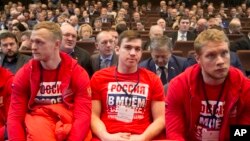 Jugadores del equipo ruso de hockey participan en una reunión del Comité Olímpico de Rusia, en Moscú. Sus camisetas dicen "Rusia en mi corazón".