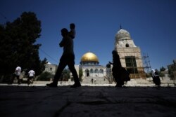 Para pengunjung berjalan di dekat masjid Al-Aqsa yang dibuka kembali setelah selama dua setengah bulan ditutup untuk meredam penyebaran virus corona (Covid-19) di Kota Tua Yerusalem, 31 Mei 2020. (Foto: Reuters)