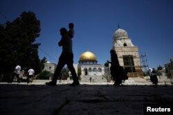 Para pengunjung berjalan di dekat masjid Al-Aqsa yang dibuka kembali setelah selama dua setengah bulan ditutup untuk meredam penyebaran virus corona (Covid-19) di Kota Tua Yerusalem, 31 Mei 2020. (Foto: Reuters)