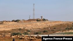 FILE - A picture take on Dec. 15, 2021 shows farmers working in their fields near the border with Israel and the Hamas-controlled Gaza Strip enclave near the town of Beit Lahia
