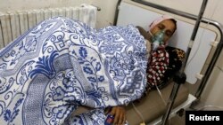 A woman, affected by what activists say was a gas attack, receives treatment inside a makeshift hospital in Kfar Zeita village in the central province of Hama May 22, 2014. Syrian opposition activists have posted a video of what they say is chlorine gas f