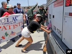 La manifestante Martha Mercado intenta detener un autobús con niños inmigrantes a bordo durante una protesta frente al Centro de Procesamiento Central de la Patrulla Fronteriza de los Estados Unidos el sábado 23 de junio de 2018 en McAllen, Texas.